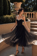 A woman wearing Vogsion Petite Structured Lace Corset Tulle Maxi Dress, standing on outdoor stone steps in a garden setting.