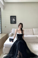 A woman wearing a Vogsion Petite Structured Lace Corset Tulle Maxi Dress, sitting on a white sofa in a modern living room.