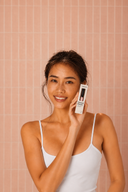 Model holding Vogsion PocketLift Mini Heated Brush packaging, a lipstick-size portable heated brush for quick bangs styling, root volume, and on-the-go frizz touch-ups.