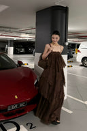 Woman in Vogsion Seraphina Tiered Chantilly Lace Maxi Dress - Romantic Pastel Coquette Gown standing in a parking garage with a red car and white van in the background.