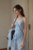 Close-up of the Vogsion Sky Mist Blue Ruffle Maxi Dress showcasing the watercolor blue floral fabric, layered chiffon ruffles, flattering V-neckline, delicate straps, and romantic feminine silhouette with elegant spring styling.