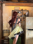 Woman in Vogsion Velvandis Off Shoulder Dot Mini Dress (Sage Green Polka Dot) standing in a rustic interior setting.