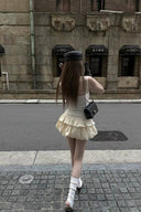 Back view of Y2K-inspired ivory skort mini dress with bubble hem and fitted upper body