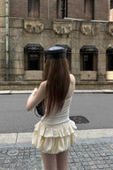 Back view of Y2K-inspired ivory skort mini dress with bubble hem and fitted upper body