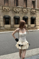 Front view of Vogsion ivory bubble hem skort mini dress styled with a black shoulder bag