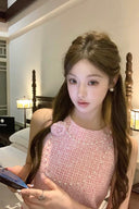 Woman wearing VOGSION Rosalie Petite Pink Tweed Mini Dress with floral detail in luxury hotel room