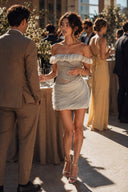 Woman wearing a ruched grey chiffon mini party dress at an elegant cocktail reception