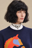 Close-up of the ribbed crew neckline and colourful horse motif on Cavelle navy sweater.