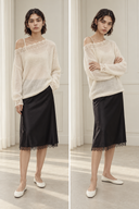 Ivory oversized wool-blend sweater with off-shoulder crochet neckline, styled with a black satin skirt.