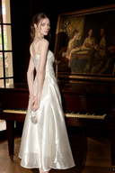 Back three-quarter view of the Isabeau ivory satin maxi dress with adjustable spaghetti straps.