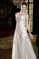 Isabeau ivory satin maxi dress in window light, showing the spaghetti straps and softly draped bodice.