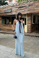 Model wearing a light blue halter top and maxi skirt two-piece set with black front tie