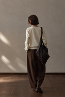 Back view of ivory wool cardigan with ribbed cuffs and hem
