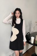 Close view of the navy and ivory wave knit mini dress and gathered white blouse