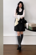Navy and ivory wave knit mini dress styled with a white blouse, full-length view