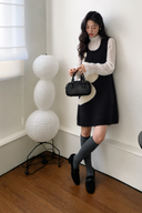 Navy and ivory wave knit mini dress styled with a white blouse, full-length view in a bright room