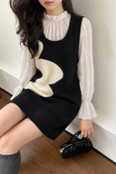 Seated styling view of the navy and ivory wave knit mini dress