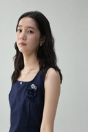 Close-up of the Odeline navy petite top showing the square neckline and attached gray and navy rosette details.