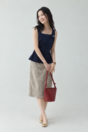 Odeline petite navy square-neck rosette top and taupe textured A-line midi skirt, styled with a burgundy bag and gold shoes.