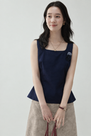 Odeline navy petite cotton-blend top with a square neckline, fitted waist and floral embellishments, paired with a taupe skirt.