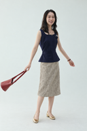 Full-length front view of the Odeline navy rosette sleeveless top and taupe textured petite midi skirt.