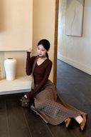 Seated view of the Odette petite skirt set showing the flowing polka dot maxi skirt and coordinating ribbon.