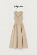 A sleeveless beige midi dress with a wide boat neckline and a small decorative button detail, displayed flat against a textured off-white background with the brand name 'Vogson' written above.