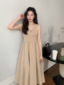 Beige sleeveless cotton knit midi dress with tonal rosette collar and gathered A-line skirt, model front view.