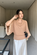 Blush batwing sweater showing its draped neckline, ribbed waistband and rabbit-fur trim along the wide sleeve openings