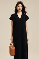 Front view of the black wool-blend knit dress showing its relaxed straight drape and cap sleeves.