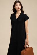 Black knit dress showing the V-neckline, ribbed cap sleeves and soft wool-blend texture.