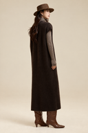 Back view of the relaxed brown wool-blend knit dress layered over a turtleneck with brown boots.