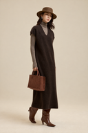 Brown V-neck wool-blend knit dress layered over a taupe turtleneck with brown boots and a suede tote, full-length view.