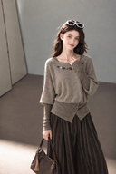 Model wearing a taupe boatneck cotton knit top with bead embellishments and contrasting brown knit cuffs.