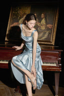 Dusty blue asymmetrical ruffle midi dress styled for a formal evening