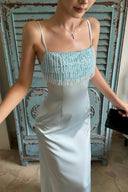 Close-up of the shimmering beaded-fringe neckline on the VOGSION Alicia light blue satin maxi dress