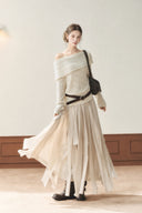 Model wearing an apricot off-shoulder pointelle knit sweater over a khaki petite A-line maxi dress