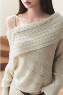 Close-up of the apricot pointelle knit sweater showing its wide draped neckline and open-knit texture