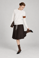 Aveline ivory wool sweater styled with a chocolate pleated skirt and brown socks