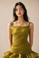 Close front view of the olive green ruched bodice and black tie straps