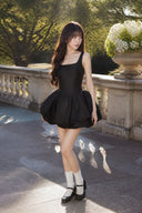 Three-quarter view of VOGSION black bubble hem mini dress