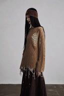 Side view of relaxed camel distressed knit pullover with white open-knit layer