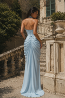 Back view of a sky blue halter chiffon maxi dress featuring an adjustable lace-up corset, ruched skirt and elegant flowing silhouette.