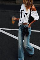 VOGSION ÉCLIPSE Petite Off-Shoulder Graphic Tee styled as a petite-friendly oversized white graphic T-shirt with vintage flare jeans, black leather shoulder bag and ballet flats, creating a chic old money inspired casual city outfit.