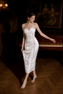VOGSION Eirene white shell-pleated satin lace midi dress, full-length piano-room view