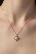 Gold tone fleur-de-lis pendant necklace with cubic zirconia center by Vogsion detail