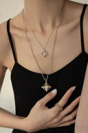 Gold tone fleur-de-lis pendant necklace with cubic zirconia center by Vogsion