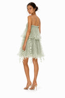 Back view of Vogsion green fairy dress showing thin straps, airy tulle layers, low back detail, and delicate leaf appliqué