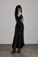 Three-quarter view of the VOGSION Iron Veil black Gothic maxi dress showing its tonal fabric, fixed crisscross front cutout and hardware-trimmed side slit.