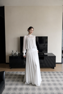 Front full-length view of the VOGSION Isolde white lace maxi dress with a high waist and sheer lace yoke.